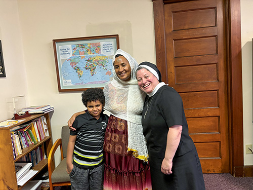 Sister posing for a picture with an foreign woman and child