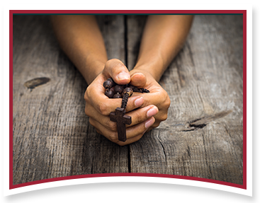 Person praying with rosary beads
