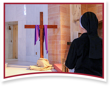 Sister praying in front of Cross